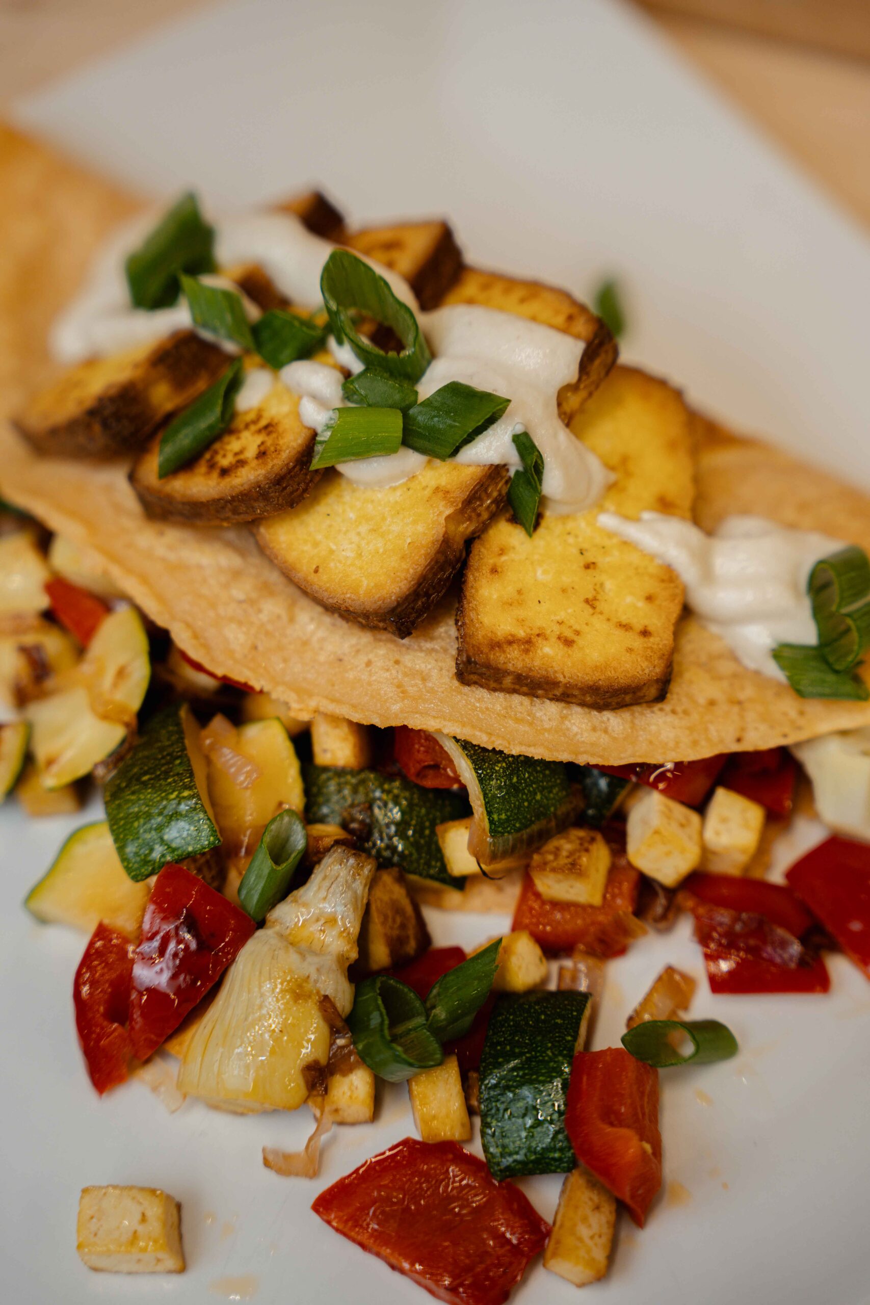 Wegański naleśnik z czerwonej soczewicy z warzywami, wędzonym tofu i wegańskim sosem czosnkowym